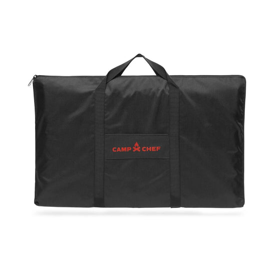 The Camp Chef Griddle Bag 16 - 2 Burner is a black rectangular bag with a zipper, two handles, a front pocket, and the red Camp Chef logo. This weather-resistant bag protects your griddle during transport.