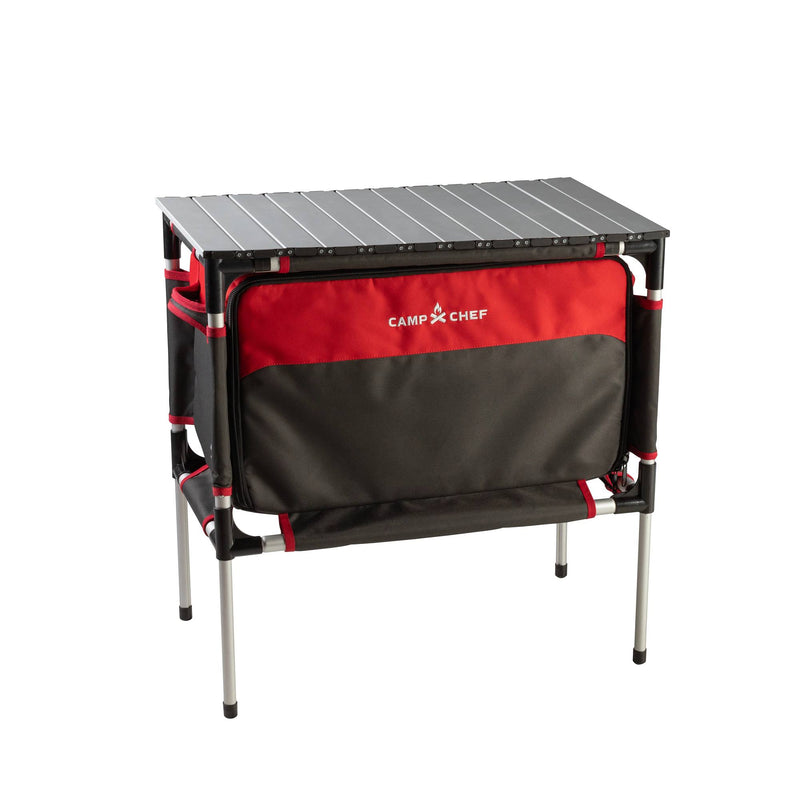 Load image into Gallery viewer, The Camp Chef Sherpa Table &amp; Organizer features a black tabletop, silver legs, and a black and red zippered storage compartment—perfect for use as a portable camp table or organizer on your outdoor adventures.
