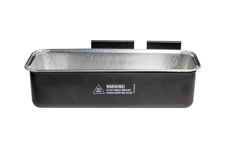 Load image into Gallery viewer, The Camp Chef Disposable Grease Cup Liner (5-Pk) is a black rectangular metal tray with a silver interior, two rear mounting brackets, and a front hot surface warning label—perfect for catching grease from your flat top griddle.
