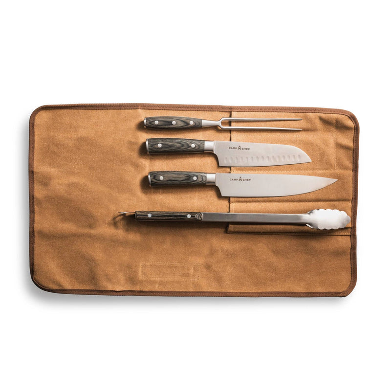 Load image into Gallery viewer, The Camp Chef 4 Piece Carving Set is shown in a tan canvas roll, featuring stainless steel knives, a carving fork, peeler, and metal tongs neatly organized against a white background.
