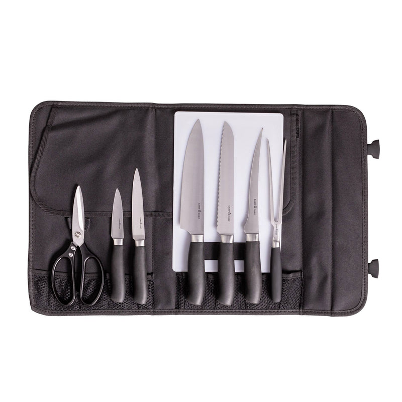 Load image into Gallery viewer, A black knife roll opens to display the Camp Chef 9 Piece Professional Knife Set, featuring six stainless steel kitchen knives, kitchen shears, and a white cutting board—all with black handles neatly organized in designated slots.
