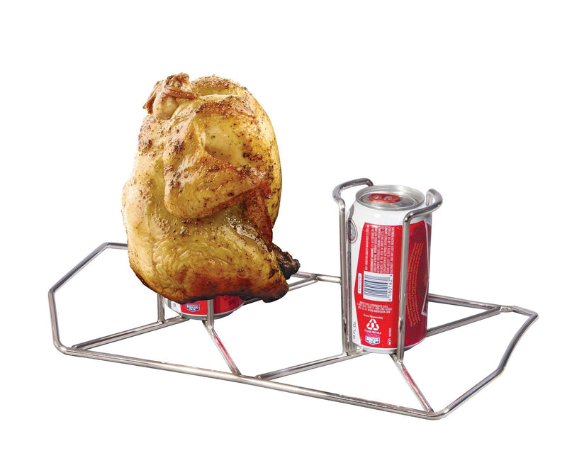 Load image into Gallery viewer, A whole chicken sits upright on an open soda can in the Camp Chef Beer Can Chicken Holder, ideal for patio grilling. The sturdy rack holds another empty can beside the bird for added convenience.
