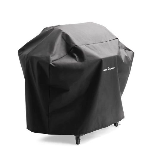 A black Camp Chef Woodwind Pro Cover fully conceals a grill, with the white Camp Chef logo displayed. Designed for Woodwind Pro pellet grills, it allows four wheels to remain visible at the bottom.