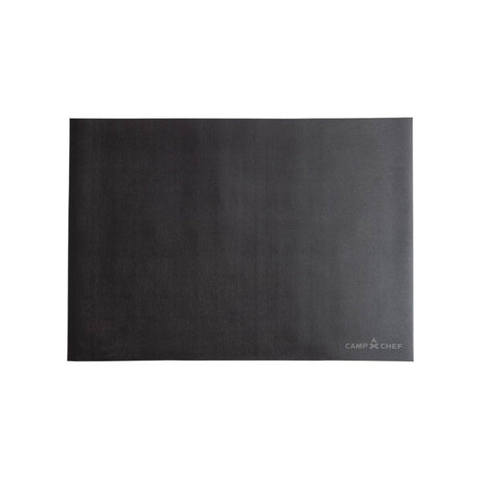 The Camp Chef Grill Mat 60 is a rectangular black mat with a smooth surface that protects your patio from grease splatter. The white Camp Chef logo appears in the lower right corner.