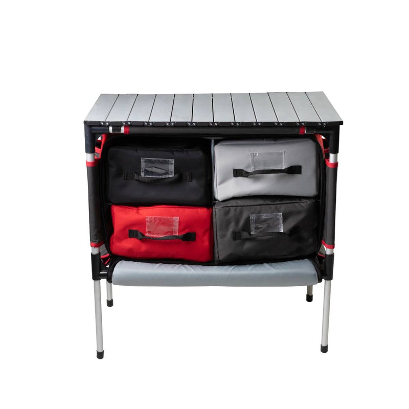 Load image into Gallery viewer, The Camp Chef Sherpa Table &amp; Organizer features a gray slatted tabletop, four black, gray, and red fabric bins, a lower shelf, and sturdy metal legs—ideal as an outdoor cooking station or camp organizer.
