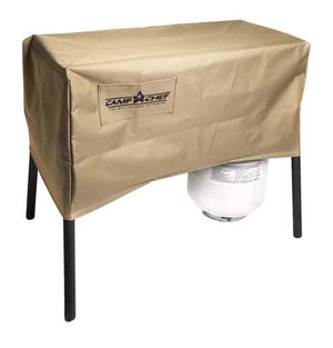A tan, weather-resistant Camp Chef 14 IN Stove Cover protects an Explorer 3X grill or stove with black legs, partially hiding a white propane tank underneath.