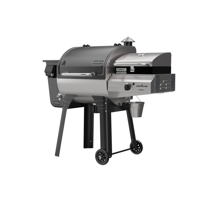 Load image into Gallery viewer, The Camp Chef Woodwind 24 is a black and silver pellet grill and smoker with a WIFI controller, chimney, pellet hopper, side shelf, two wheels for mobility, plus main and side cooking chambers for added versatility.
