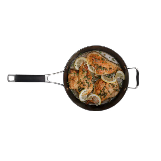 A top-down view of cooked chicken breasts with lemon and herbs in a Heritage Skillets pan by Camp Chef highlights the searing performance and quality craftsmanship of this cast iron cookware.