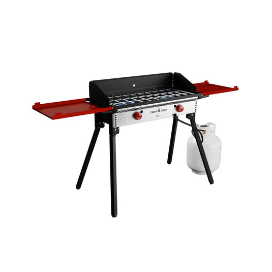 The Camp Chef PRO 14 is a portable propane grill featuring a silver and black body, two red knobs, red side shelves, four black legs, and a right-side propane tank—ideal for outdoor cooking with the trusted Camp Chef system.