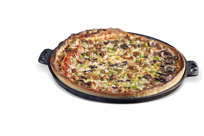 Load image into Gallery viewer, A whole baked pizza with cheese, mushrooms, and green peppers sits on a Camp Chef Cast Iron Pizza Pan with decorative handles, isolated on a white background.
