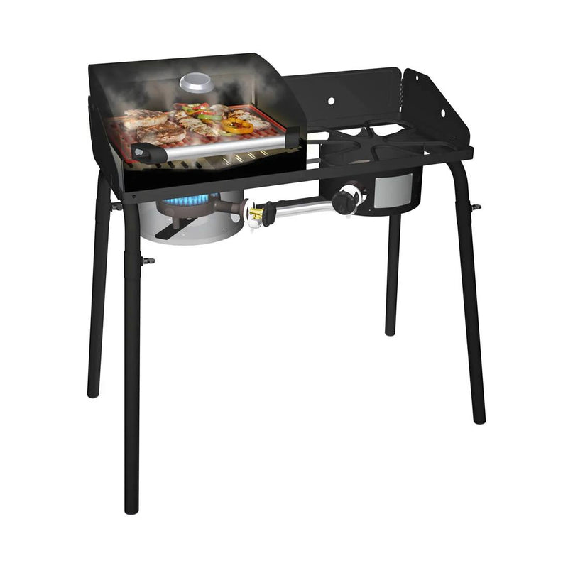 Load image into Gallery viewer, The Camp Chef BBQ Grill Boxes 14, a black propane grill with a griddle top and cast iron surface, is shown cooking meat and veggies. It has two burners (one in use), smoke rising, sizzling food, side shelf, and sturdy legs for support.
