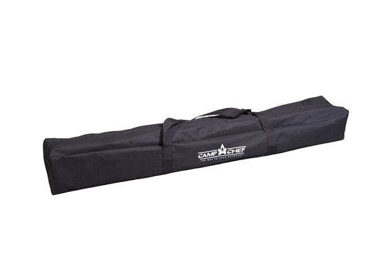 A long black rectangular carrying bag with two handles and the Camp Chef logo in white, designed to store the Mesa Aluminum Camp Table by Camp Chef, shown against a plain white background.