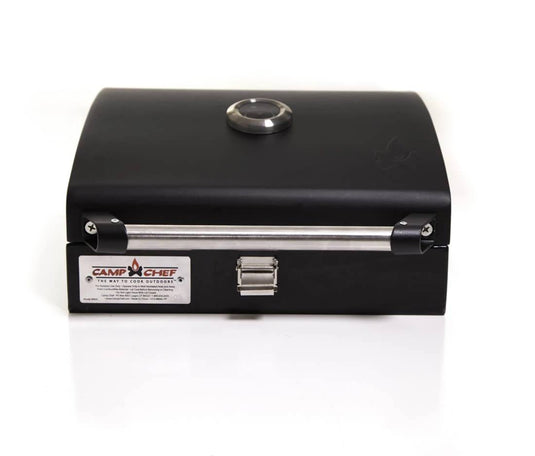 The Camp Chef BBQ Grill Boxes 14 is a black professional grill box with a heat diffuser system, silver handle, and built-in lid thermometer. It boasts a durable cast iron grilling surface and is shown against a white background.