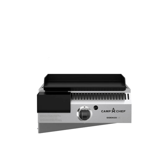 The Camp Chef Sidekicks is a stainless steel propane burner grill attachment with a control knob, black griddle top, and vented sides, displayed on a plain white background.