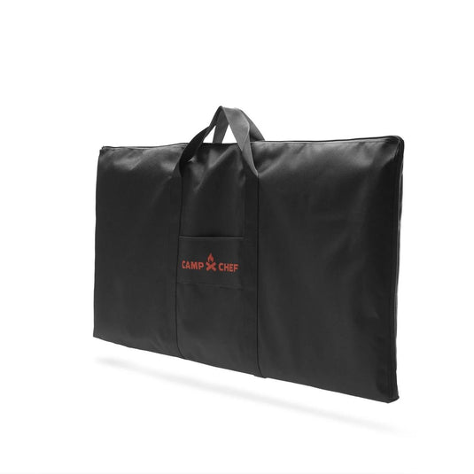 The Camp Chef Griddle Bag 14 - 2 Burner is a large black rectangular bag with handles, a front pocket featuring the red Camp Chef logo, an EZ glide zipper, and a weather-resistant liner. Shown against a white background.