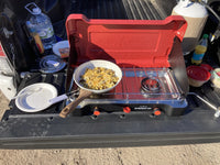 Portable stove with a pan on top, set up in a vehicle