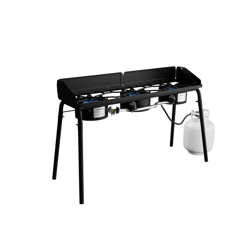 Load image into Gallery viewer, The Camp Chef Explorer is a black, two-burner cooking system with four legs, shown connected to a white propane tank on the right against a white background—ideal for outdoor cooking.
