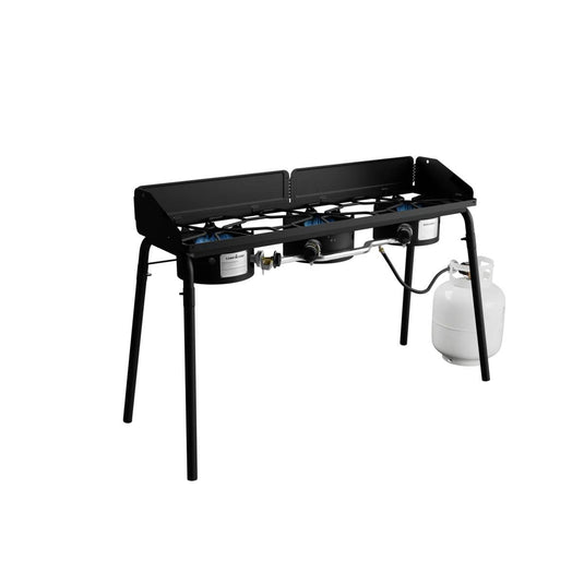 The Camp Chef Explorer is a black, two-burner cooking system with four legs, shown connected to a white propane tank on the right against a white background—ideal for outdoor cooking.