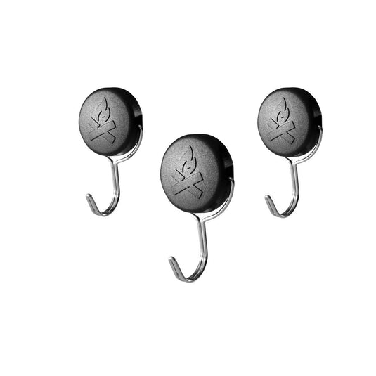 Camp Chef Magnetic Tool Holders - 3 Pack are shown in black with silver hooks and a flame logo, displayed on a white background. These round holders are perfect for organizing grilling tools.