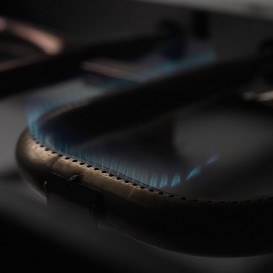 Close-up of a gas stove burner with blue flames